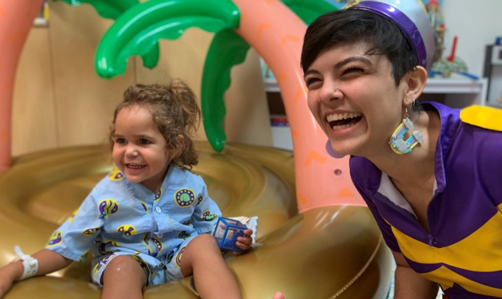 A Starlight employee and child smile and laugh at the camera