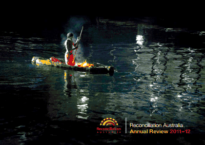 Cover of Reconciliation Australia Annual Review 2011-2012. Image shows an Indigenous man in traditional dress on a boat in the middle of a body of water.