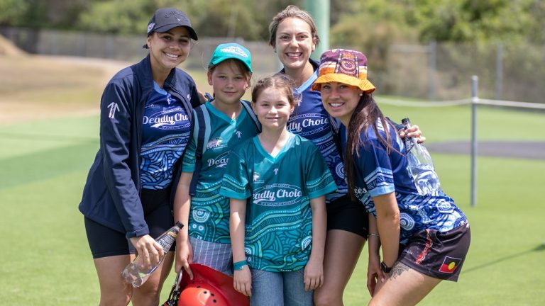 Two young people and three supervisors in Deadly Choices shirts.