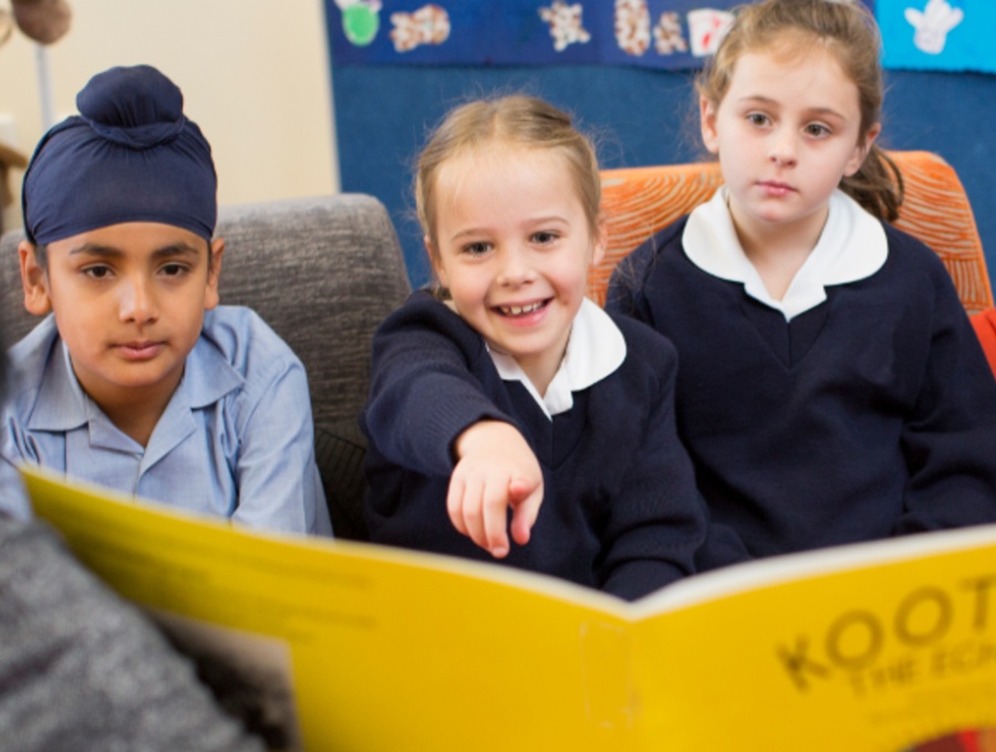 Young students reading a book together