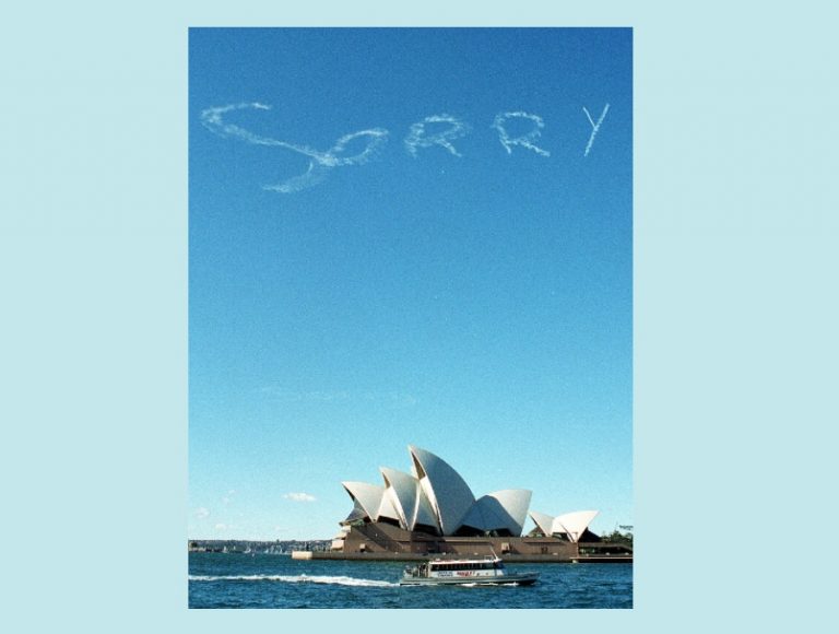 Image of Sydney Opera House with the word 'Sorry" written in skywriting above it.