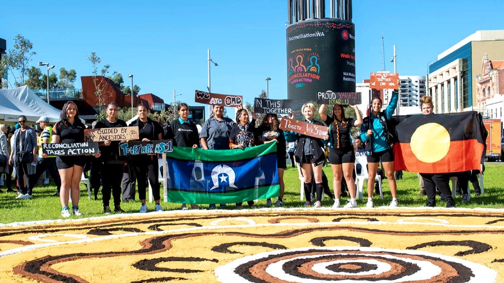 A group of women holding Aboriginal and Torres Strait Islander flags at the Perth Walk for Reconciliation.