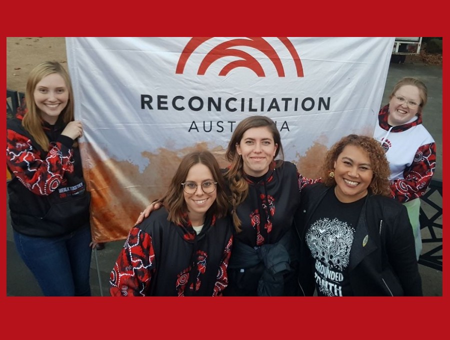 Members of Reconciliation Australia Staff standing in front of Reconciliation Australia Banner.