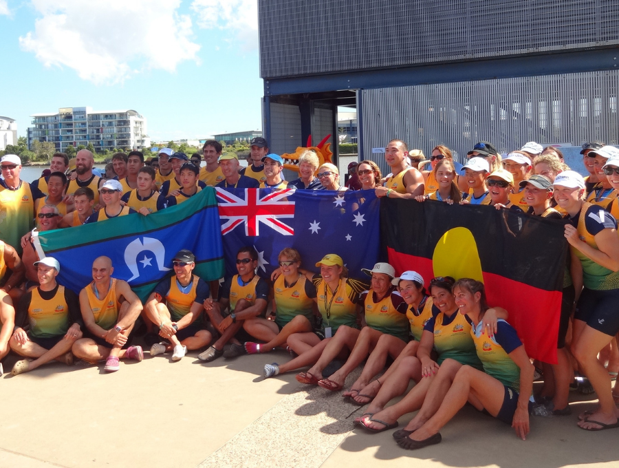 Adrian Andrews with team mates holding Indigenous & Australian flags