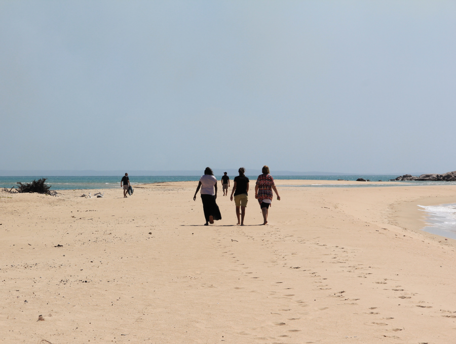 Ingrid Cummings & others walk along beach during 2015 Garma trip.