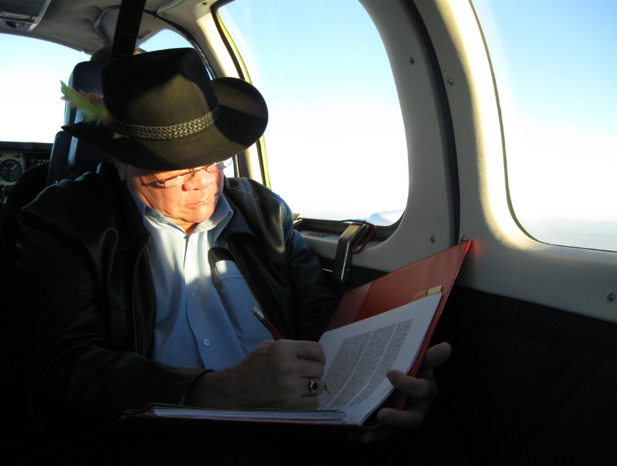 Professor Mick Dodson taking notes while travelling by plane