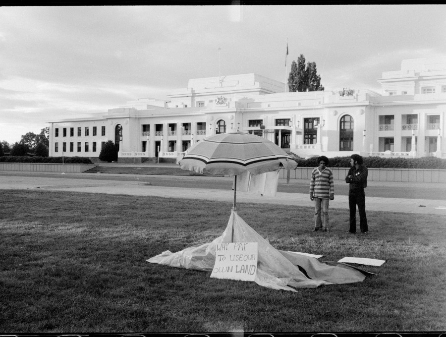 Image of Billy Craigie and Michael Anderson setting up the Aboriginal Tent Embassy in front of Old Parliament House, on Ngunnawal Country (Canberra), on 27 January, 1972. Their sign reads, ‘Why pay to use our own land?’