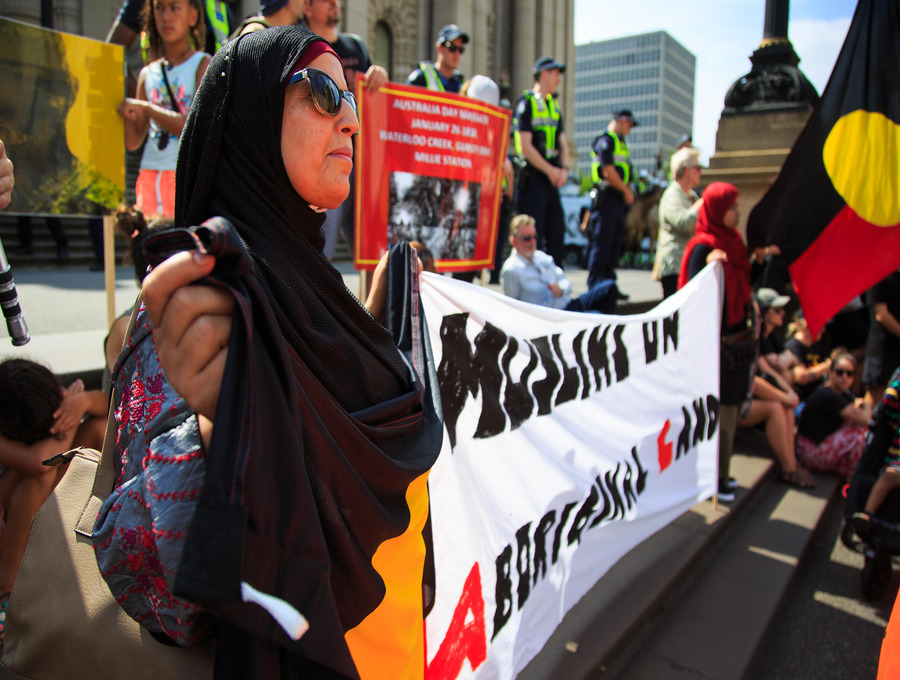 Australia’s multicultural communities have a unique role to play in standing with Aboriginal and Torres Strait Islander peoples. Here a woman attending an Invasion Day rally in Melbourne on Wurundjeri Country holds a banner reading ‘Muslims on Aboriginal Land’.
