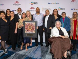 A group of people from Aboriginal Health & Medical Research Council Human Research Ethics Committee stand together holding their award.