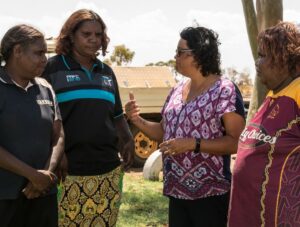 Four women stand outside talking