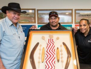 Employees pose with IGA judge and large framed artwork