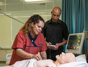 Two employees at Marr Mooditj Training Aboriginal Corporation demonstrate a health check on a dummy