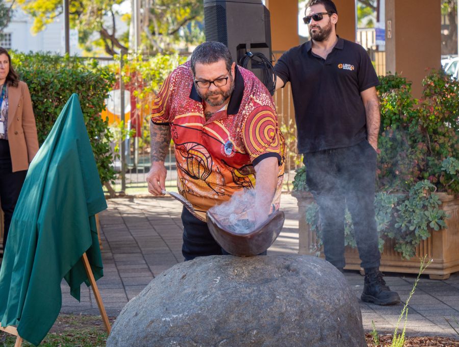 A man dips his hand into a bowl of smoke.
