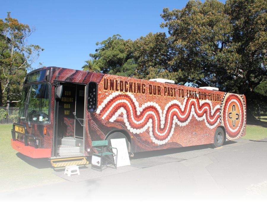 A bus with a large Aboriginal art design across the side