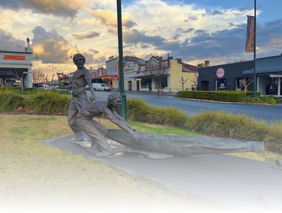 A statue of two Aboriginal men pushing a canoe out