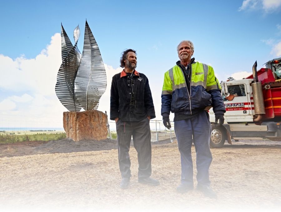 Two men standing in front of a newly-installed sculpture