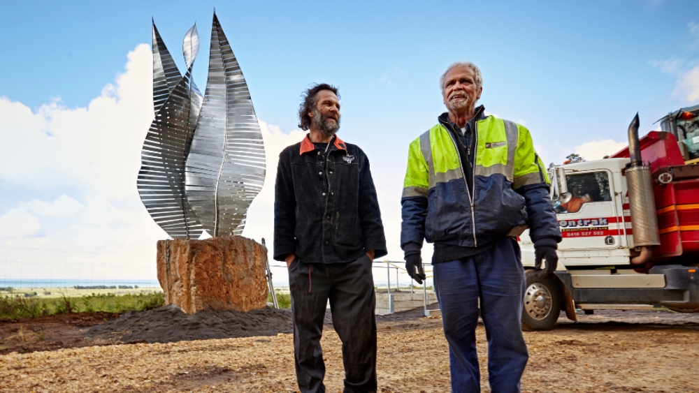 Two men standing in front of a newly-installed sculpture.