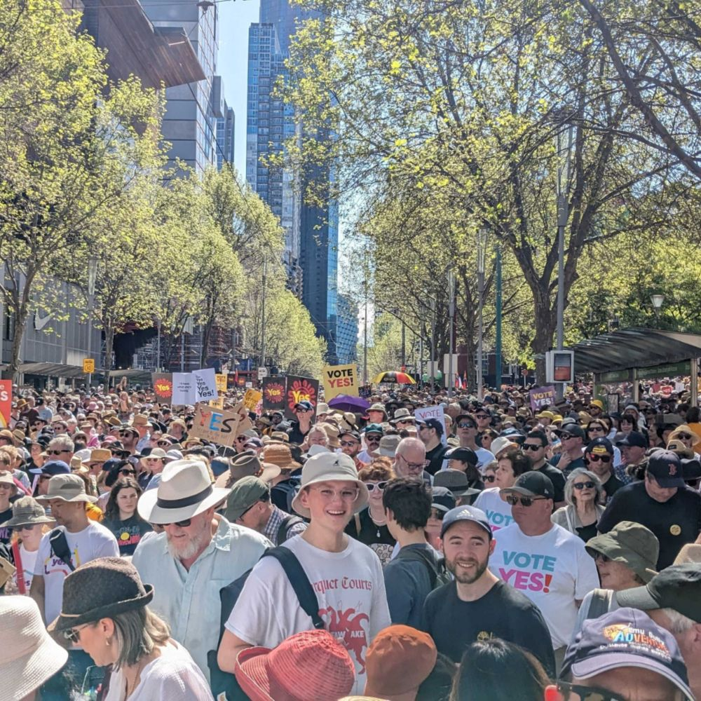Crowd of people at wearing shirts and signs that read 'Vote YES!'.