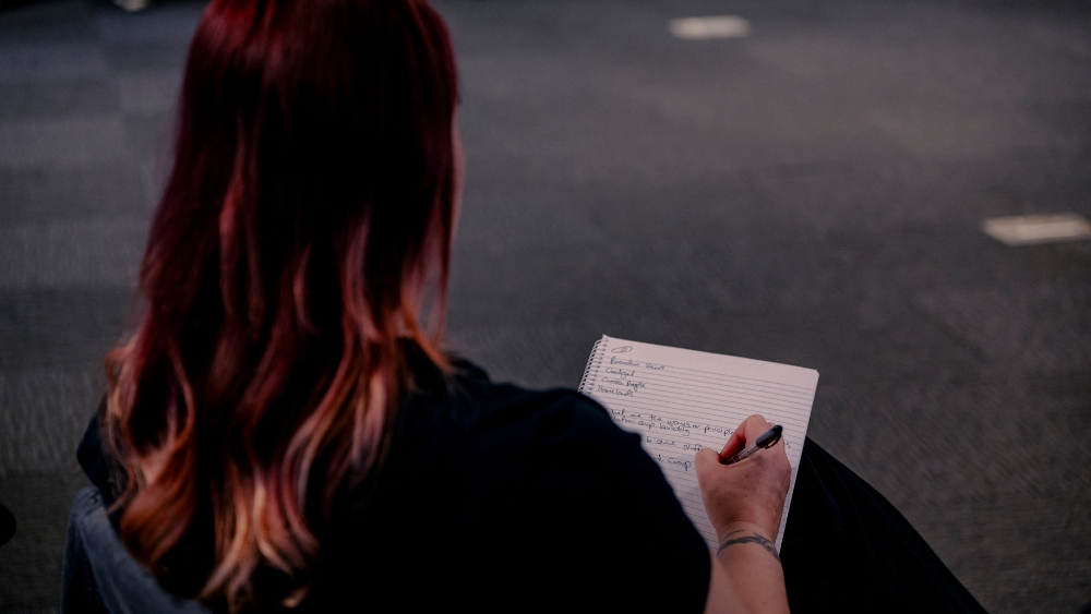 A woman takes notes on a notepad.